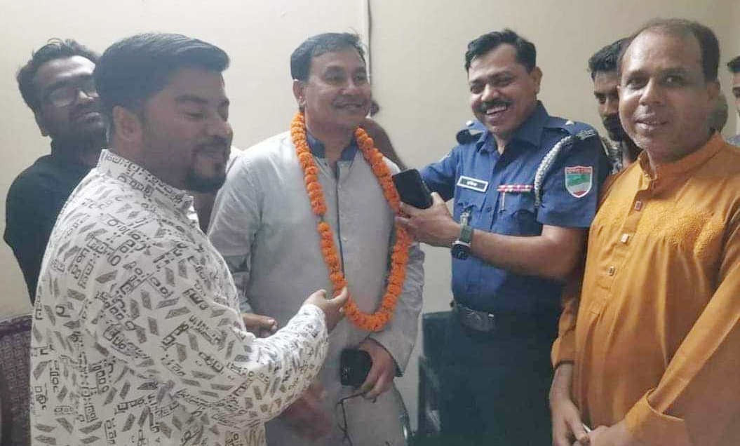 বিজয়ী প্রার্থীর গলায় ফুলের মালা দিলেন ওসি